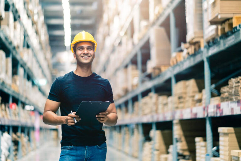 Who We Serve 9 A warehouse worker with a tablet between stocked aisles