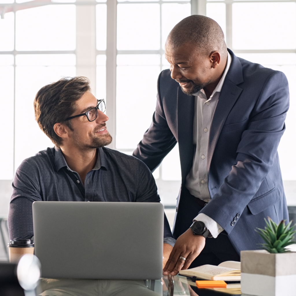 AI Readiness Assessment: Is Your Business Actually Ready for AI? 1 Man with an employee gathered around a computer during a technology training session, with the person demonstrating software.